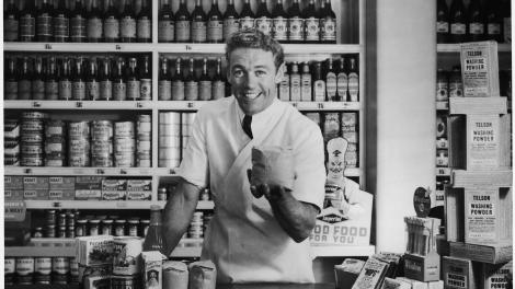 A shop grocer excitedly dealing with a customer